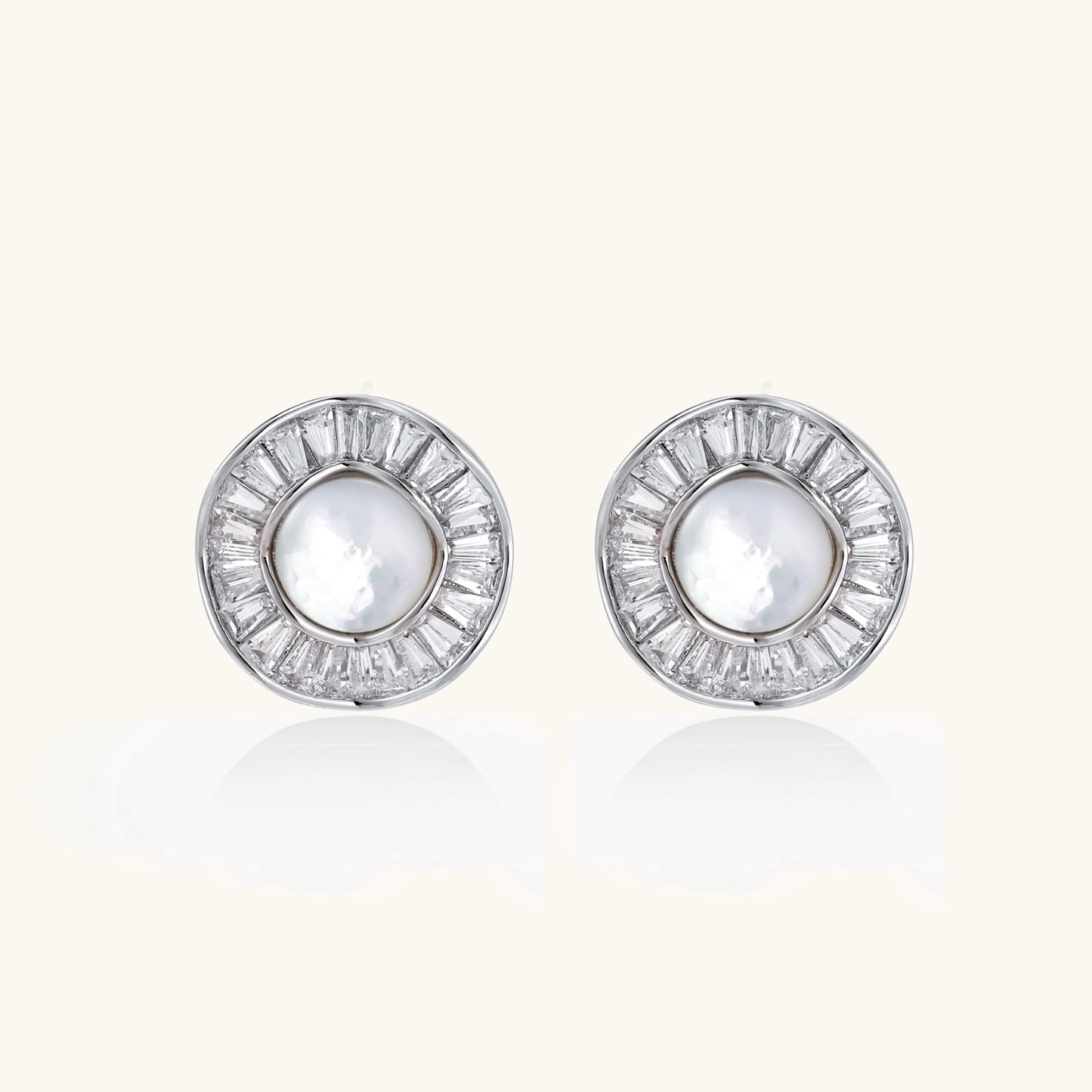 White gold-plated stud earrings with iridescent pearl centers surrounded by baguette crystal halos on white background.