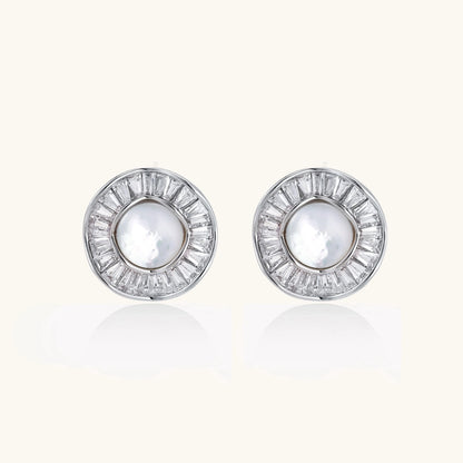White gold-plated stud earrings with iridescent pearl centers surrounded by baguette crystal halos on white background.